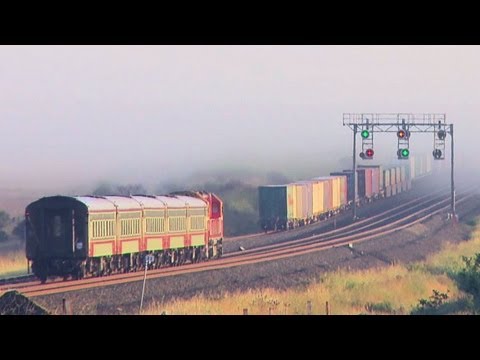 Passenger Train and Long Freight Train pace each other towards a wall of fog - PoathTV