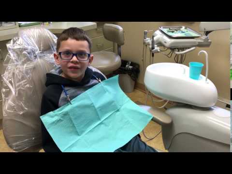 Young boy with glasses in dental chair