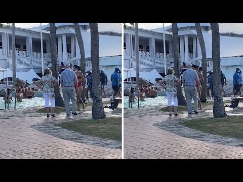 Elderly couple adorably dance together while on vacation