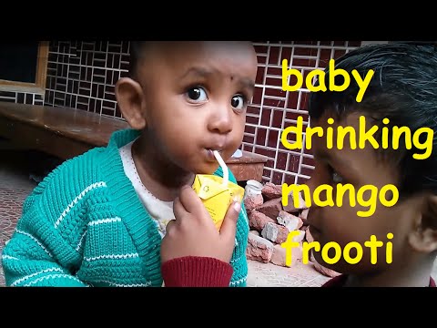 Funny baby drinking mango frooti