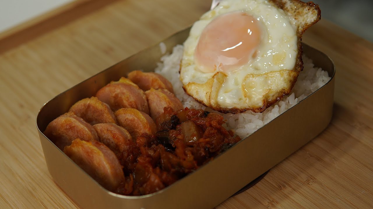 A classic Korean dosirak lunchbox arranged with rice kimchi rolled egg omelet bulgogi and various banchan side dishes in compartments
