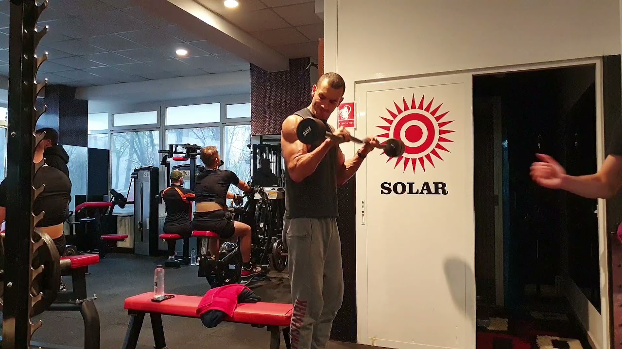 Flexii pentru biceps/antebrațe, din stând, cu bara Z și priză pronată