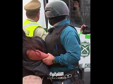 شاهد بالفيديو.. امرأة تصيب رجال أمن بعد سرقتها مسدساً من شرطي أثناء اعتقالها في #تشيلي