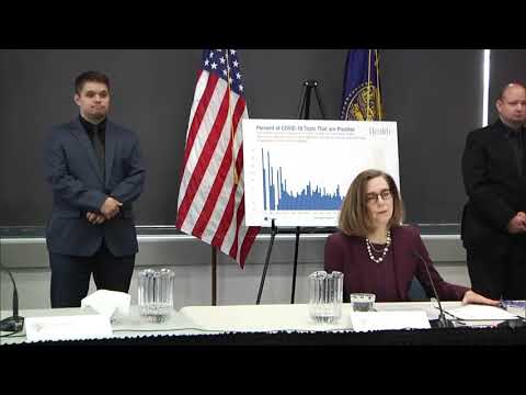 Governor Kate Brown presenting at the June 3rd press conference with a chart and two sign language interpretors in the background