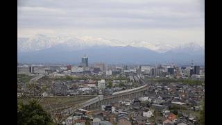 立山連峰をバックに走行する北陸新幹線、呉羽山展望台から