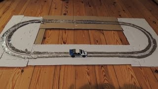 Home made slot car track of cardboard, aluminum foil and staples