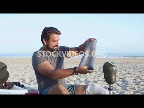 man putting his prosthesis on after surf...