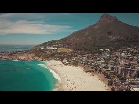A Crowd Of People Out And Enjoying The Beach On A Sunny Day