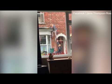 Video: A woman crashes to the ground after danling from a window