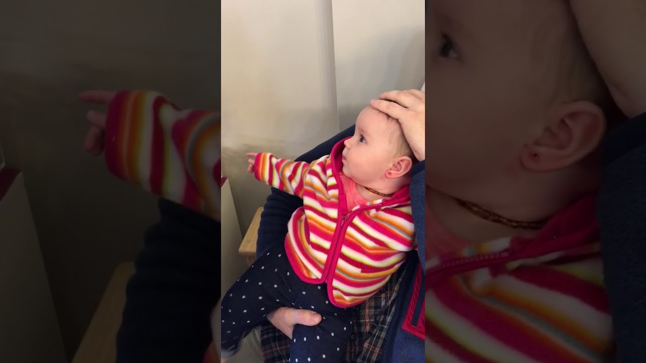 Baby girl getting ears pierced giggling away