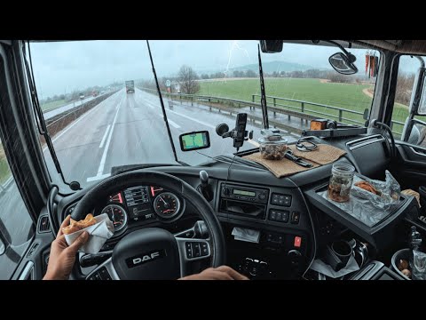 A very hungry truck driver ate while driving at full speed in the rain
