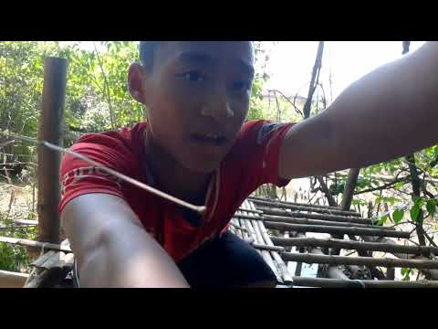 Huy sat by the bamboo house and Uncle Quang came down to watch