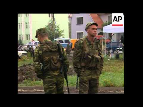 Footage of school; troops outside; relatives await news