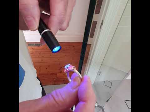 UV light passes through thick glass and causes fluorescence in diamonds indoors.