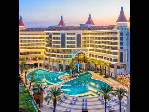 Außenansicht des Kirman Leodikya Resorts mit großen Swimmingpools und Palmen