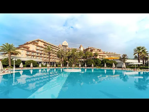 Außenansicht des IC Santai Family Resort mit großem Swimmingpool und roten Sonnenschirmen.