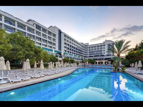 Außenpool des Gloria Serenity Resorts mit luxuriösen Gebäuden und Liegestühlen.