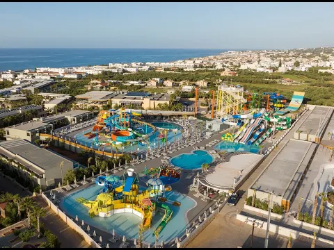 Außenbereich des Stella Village Hotels mit Pool, Liegen und Sonnenschirmen