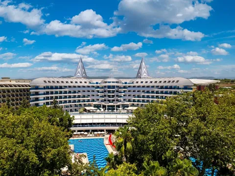 Luftaufnahme des Botanik Platinum Hotels mit Swimmingpools und grüner Umgebung.