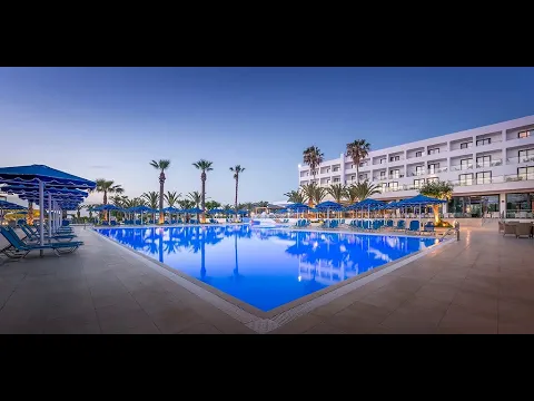 Außenansicht des Mitsis Faliraki Beach Hotel & Spa mit Swimmingpool und Palmen.