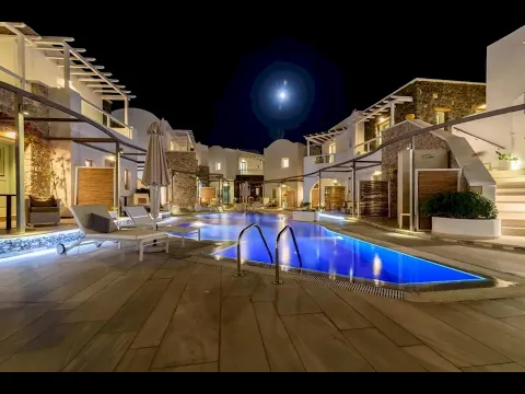 Nachtansicht des Swimmingpools im La Mer Deluxe Hotel & Spa mit leuchtend blauem Wasser und umliegenden Gebäuden.