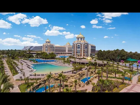 Luftaufnahme des Delphin BE Grand Resort mit Swimmingpools, Gebäuden und Bäumen.