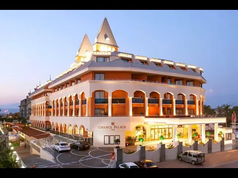 Das Orange Palace Hotel Nebengebäude bei Nacht mit Beleuchtung und Fahrzeugen vor dem Gebäude.