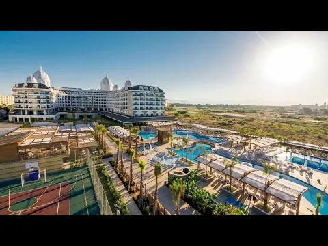 Außenansicht des Adalya Elite Lara Hotels mit Swimmingpool und Tennisplatz.