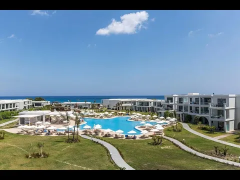 Außenbereich des Asterias Beach Resort Hotels mit Swimmingpool und Sonnenliegen.