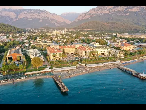 Luftaufnahme des Fame Residence Kemer & Spa Hotels mit Swimmingpool, Strand und Bergpanorama.