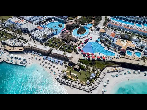 Luftaufnahme des Minos Imperial Beach Resorts mit mehreren Pools, Sonnenliegen und Pavillons.