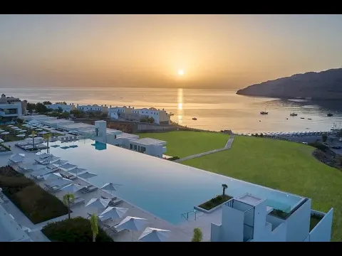 Luftaufnahme des Lindos Grand Resort & Spa mit großem Pool, Sonnenliegen und Schirmen.