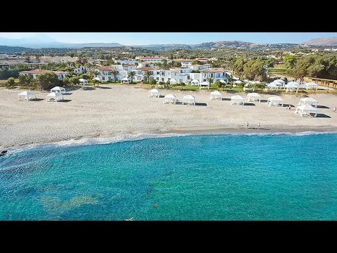 Aussenansicht des Grecotel Caramel Boutique Resorts mit Swimmingpool und Palmen