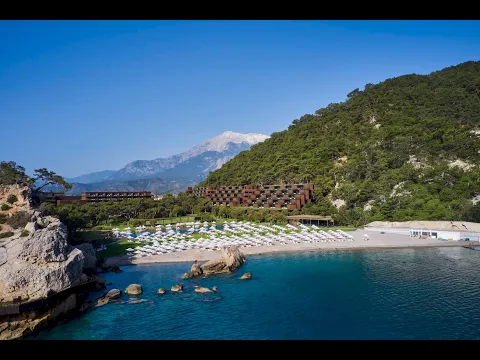 Luftaufnahme des Maxx Royal Kemer Resorts mit Swimmingpools und weißen Liegestühlen am Strand.