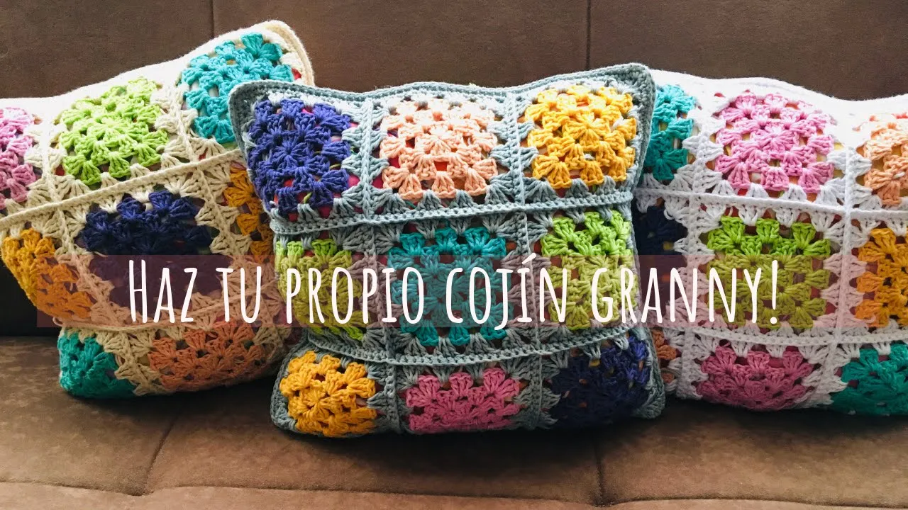 Cojines a crochet con cuadros granny de colores y bordes claros, unidos para formar fundas cuadradas.