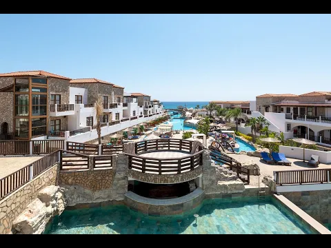 Nachtansicht des Poolbereichs des Costa Lindia Beach Resorts mit Lounge-Stühlen und Sonnenschirmen