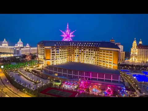 Luftaufnahme des Royal Seginus Hotels bei Nacht mit beleuchteter Fassade und Sternendekoration