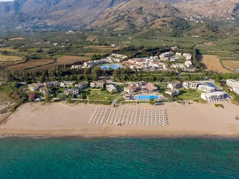 Luftaufnahme des Pilot Beach Resorts mit vielen Gebäuden und Swimmingpools am Strand