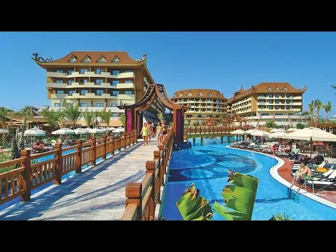 Außenbereich des Royal Dragon Hotels mit Swimmingpool, Brücke und Sonnenliegen.