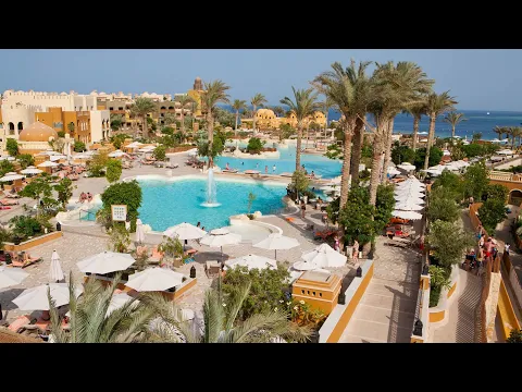 Luftaufnahme des Grand Waterworld Makadi Hotels mit Pools, Palmen und Meer im Hintergrund.
