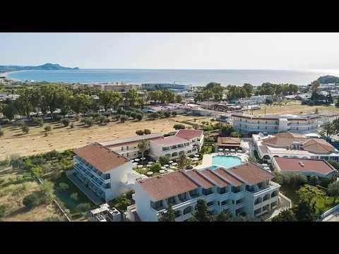 Ein großer Swimmingpool am Niriides Beach Hotel mit weißen Sonnenliegen und Sonnenschirmen.