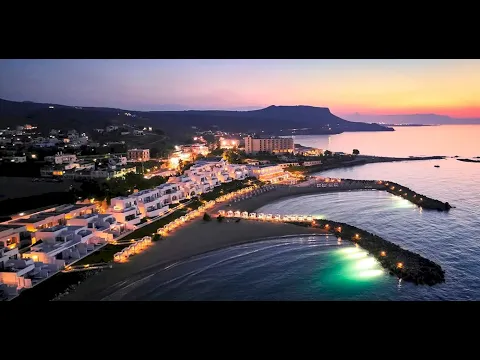 Knossos Beach Bungalows Suites Resort & Spa bei Sonnenuntergang mit beleuchteten Gebäuden und Strand