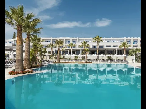 Außenbereich des Mitsis Rodos Village Beach Hotel & Spa mit großem Pool und Sonnenliegen