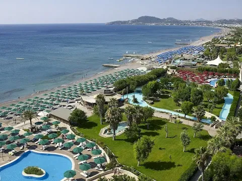 Luftaufnahme des Esperos Village Blue & Spa Resorts mit Strand, Pools und Wasserrutschen.