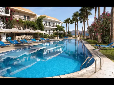 Abendansicht des Almyrida Beach Hotels mit Swimmingpool und Lounge-Liegen.