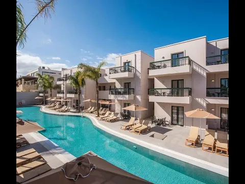 Außenpool des Gouves Water Park Holiday Resort mit grünen Liegestühlen und Sonnenschirmen.