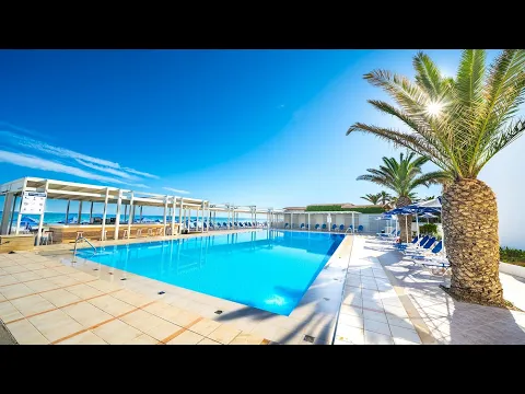 Aussenansicht des Adele Beach Hotels mit weissen Gebaeuden und Gartenanlage