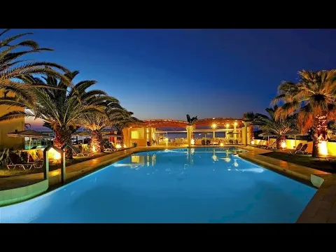 Der Poolbereich des Eva Bay Hotels bei Nacht mit Palmen und beleuchteten Liegestühlen.