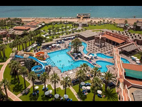 Luftaufnahme des Megasaray Club Belek Resorts mit großen Swimmingpools, Wasserrutschen und umliegenden Palmen.