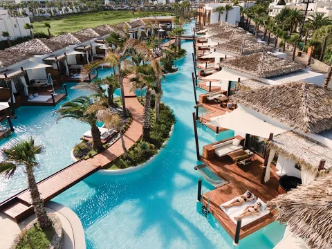 Aussenbereich des Stella Island Luxury Resort & Spa mit Swimmingpools und Palmen